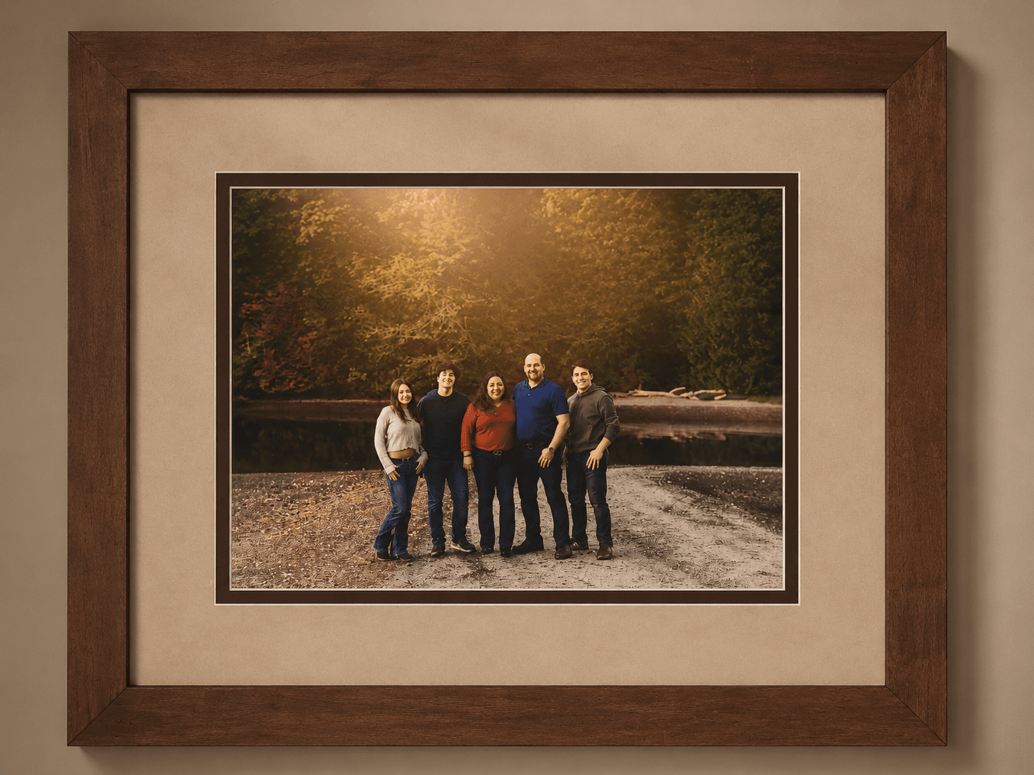 Family portrait framed in a warm walnut frame with a wide linen mat and dark accent bevel by Redhawk Framing Studio in Vancouver, WA