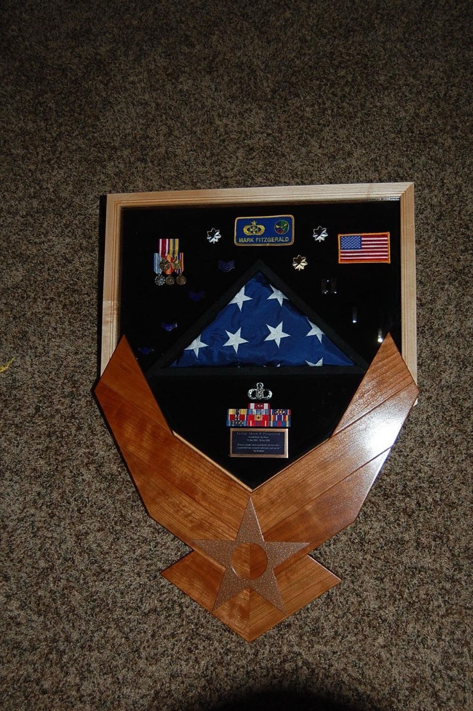 Wooden veteran flag case displaying a folded American flag with a service tribute, handcrafted by Redhawk Framing Studio in Vancouver, WA